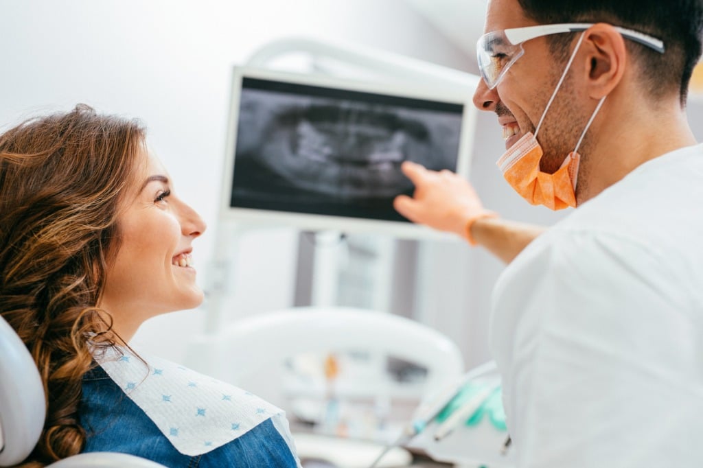 dentist-showing-a-patient-her-xray-picture-id654945798